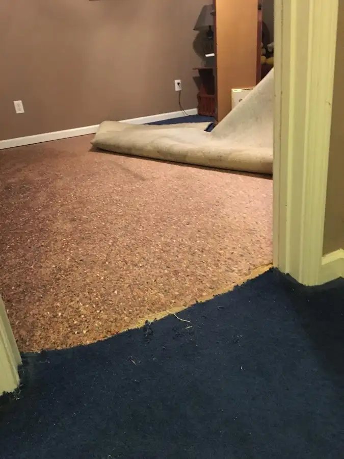 Carpet pad removal revealing water damage during Water Mitigation Services in Youngtown